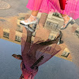 A person in heels steps through a puddle.